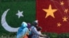 FILE - A family rides past a decoration in the shape of the national flags of China and Pakistan installed along a road ahead of a visit by Chinese Vice Premier He Lifeng, in Lahore, Pakistan, July 30, 2023.